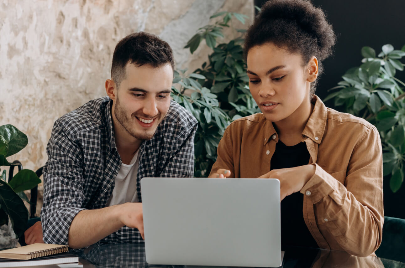 Two people working on a laptop. Growth Heroes - business experts