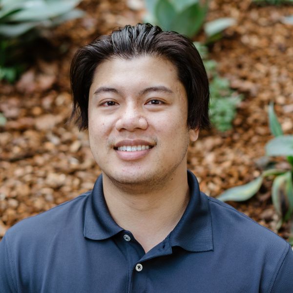 a professional headshot of Phanith Lim smiling with plants in the background.