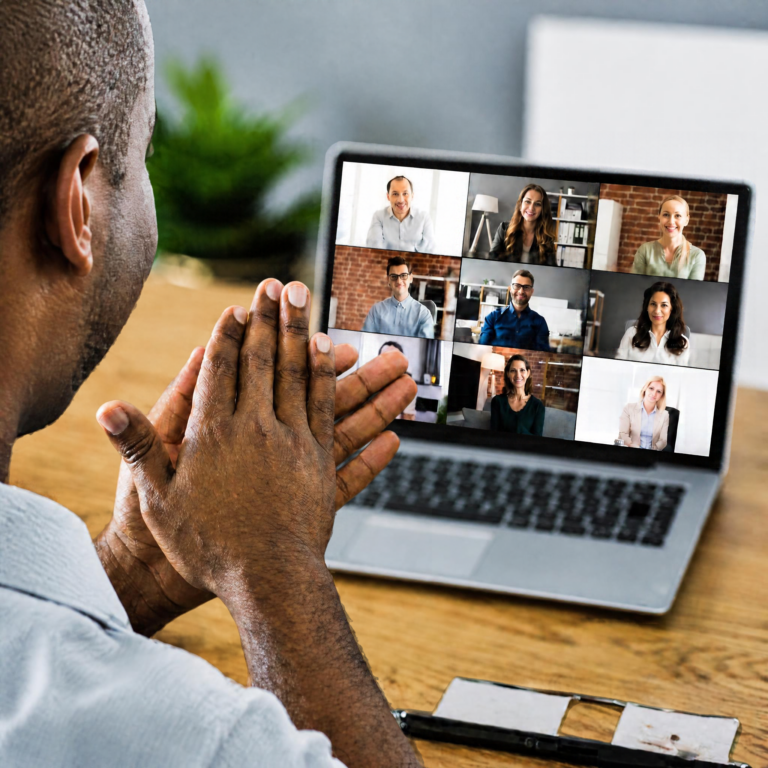 Remote worker clapping hands together in the foreground while many people join a virtual call looking on in the background.